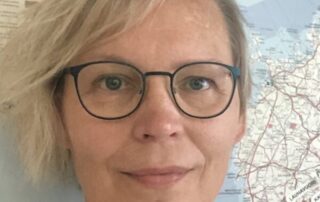 Kuvassa näkyvät Päivi Pälvimäen kasvot. Taustalla näkyy Suomen seinäkartta.