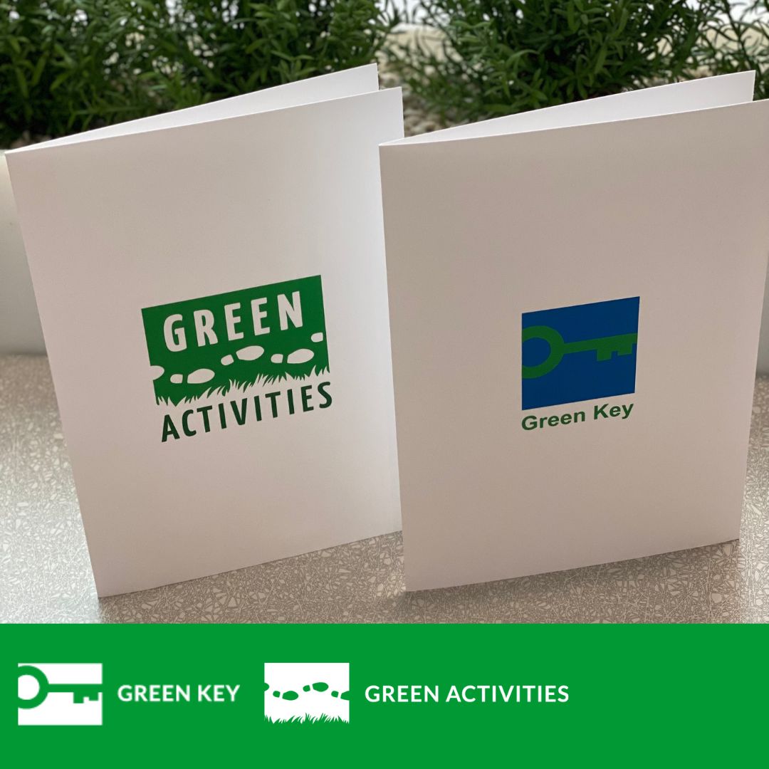 Green Key ja Green Activities kansiot pöydällä.