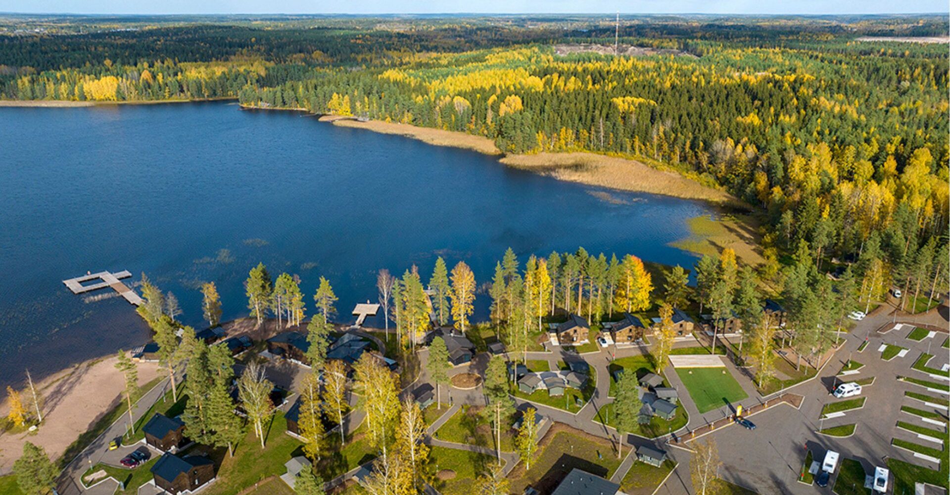 Ilmakuva Käyrälammesta ja sitä ympäröivästä metsästä sekä Tykkimäki Resort majoitteista.